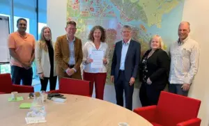 Groepsfoto bestuurders en ambtenaren gemeente Amsterdam en gemeente Ouder-Amstel